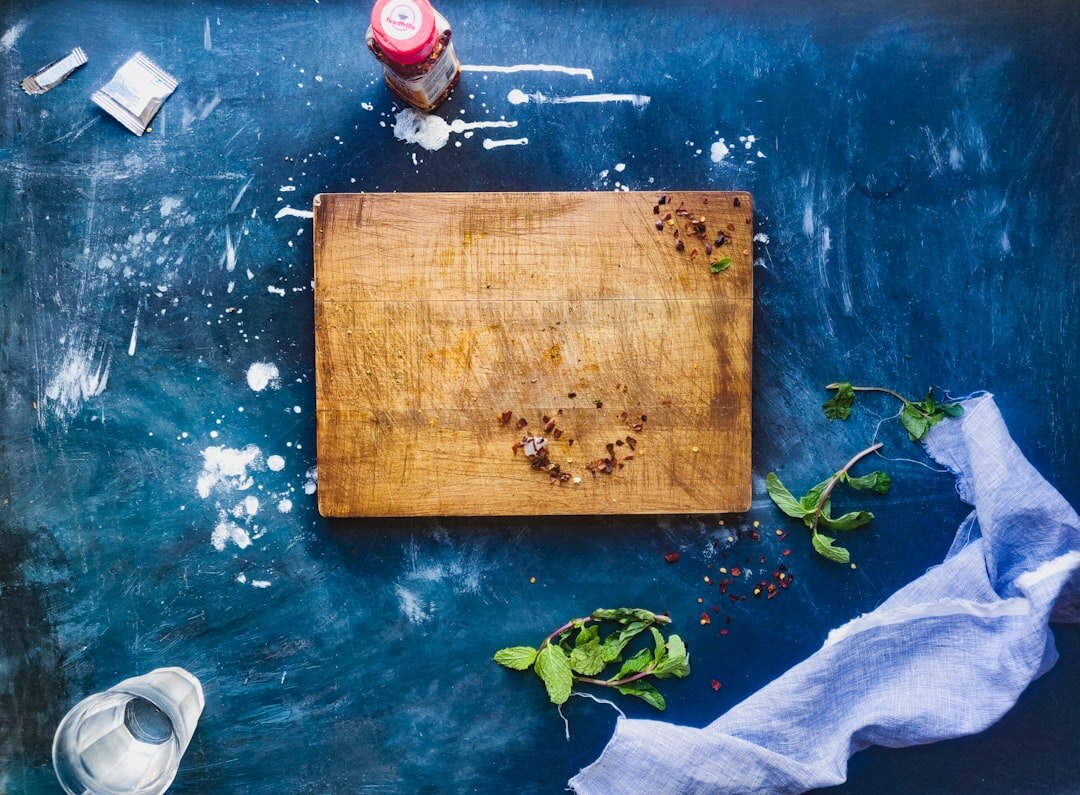 Wooden kitchen counter with fresh herbs, spices and a notebook